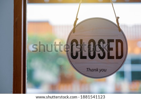 
A sign labeled as closed and thank you for hanging it in the clear glass shop front.