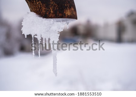 Frozen water in the downspout in the winter in Russia.