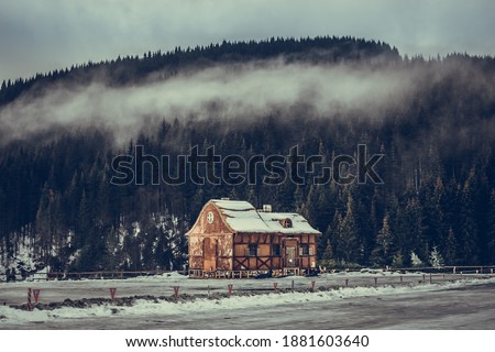 The decoration of the house mysteriously stands on a mountain in a pine forest. cozy house in a mountain forest. foggy forest