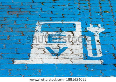 sign for electric vehicle charging on  the road with selective focus on the E
