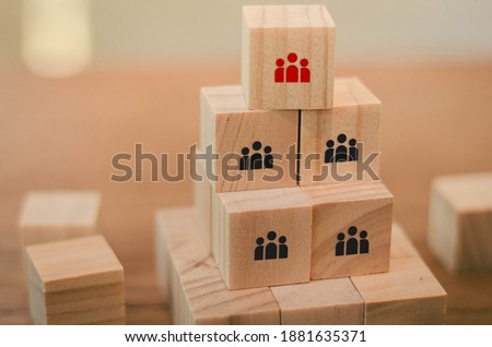 A wooden block with a businessman sign has one red idea that is different from them, that is a business idea.