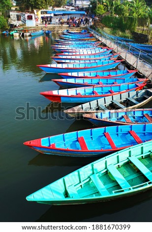 Lot of wooden blue and green boats at the lake station in Pokhara, Nepal, rowboats
