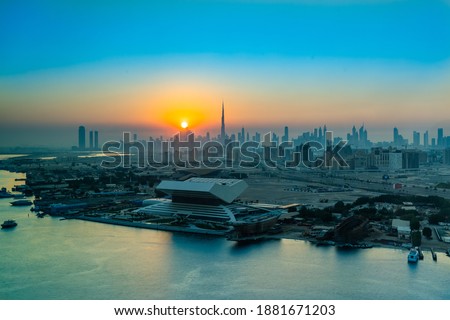 Sunset or sunrise in Dubai view to downtown or Mohammed bin Rashid Library, panorama of Dubai. Sun sets over the skyscrapers or buildings in modern city