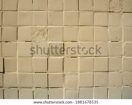 Damaged cream, beige blocks pattern wall background of small squares in beige tones