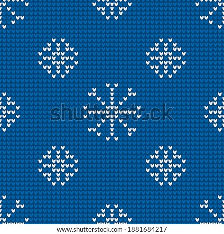 Seamless knitting pattern with snowflakes is on the blue background. Save with the Clipping Mask.