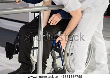Senior Man Being Assisted By Physiotherapist In Rehab Center. High quality photo