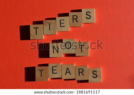 Tiers not Tears, words in wooden alphabet letters isolated on red background Royalty-Free Stock Photo #1881691117
