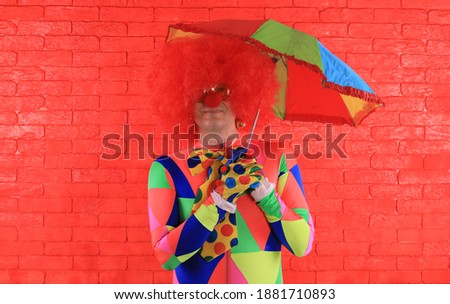 portrait of a clown on a red brick wall background