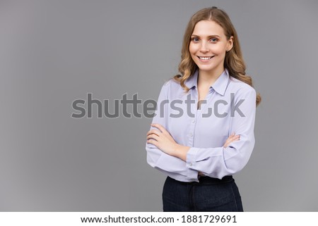 Portrait of a happy young business woman isolated on grey background