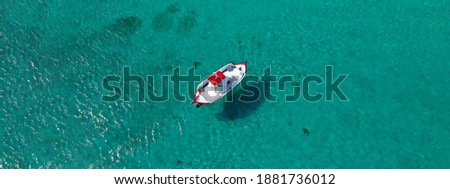 Aerial drone ultra wide photo of traditional fishing boat cruising in small Cycladic island of Schinoussa, Aegean Sea, Greece