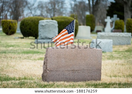 Headstone with an American Flag in a Cemetery