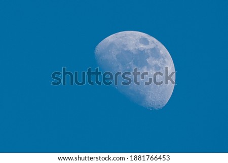 Blurred half moon on blue sky on daytime
