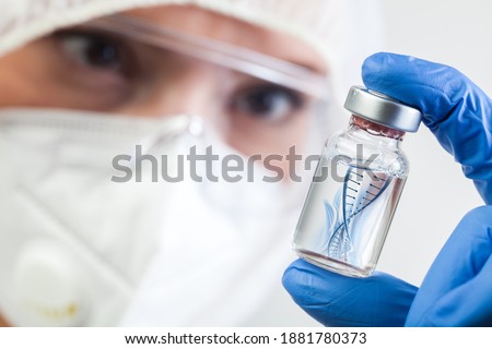 Female NHS UK lab microbiologist biotechnician holding glass bottle vial with DNA helix strand float in liquid,Coronavirus new strain mutation,novel Omicron variant,COVID-19 pandemic crisis outbreak Royalty-Free Stock Photo #1881780373