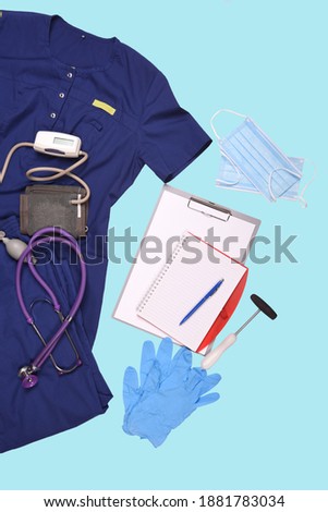 Doctor's tools and clothing with documents to fill out on an isolated blue background with medical masks and gloves