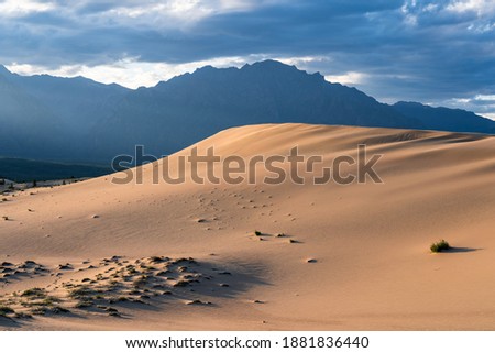 Sandy hill of Chara sands against the background of mountains Royalty-Free Stock Photo #1881836440