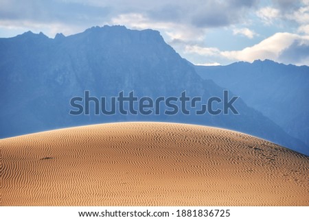 The hill of the Chara desert against the background of the Transbaikal mountains Royalty-Free Stock Photo #1881836725