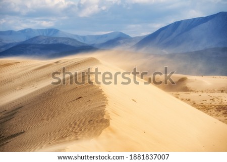 Sandy hill with mountains in the background Royalty-Free Stock Photo #1881837007