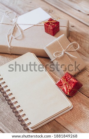 Christmas gift box Use brown recycled paper and notepad on a wooden table.