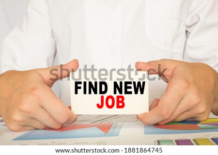a man in the office holds a card with text FIND NEW JOB . business concept