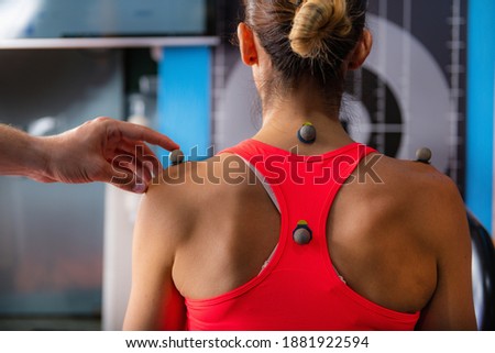 Technician placing markers on athletes shoulder, preparing for 3D gait or movement analyses   Royalty-Free Stock Photo #1881922594