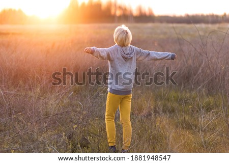 a girl enjoys the sunset in the fields in autumn.