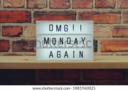 Monday Again word in light box on brick wall and wooden shelves background