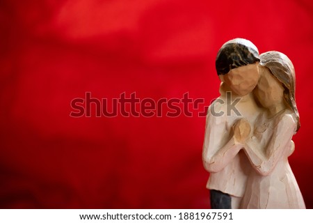 A romantic wooden couple figure with a red background