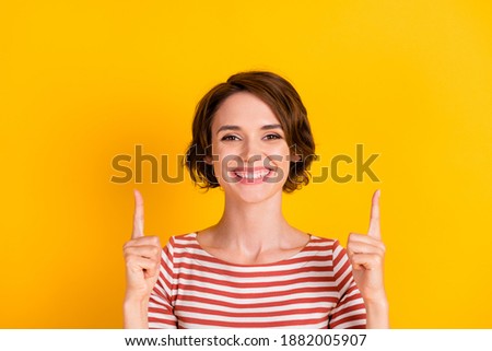 Close up portrait of pretty person smile pointing two fingers up isolated on vibrant yellow color background