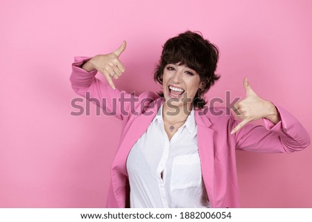 Young business woman over isolated pink background shouting with crazy expression doing rock symbol with hands up