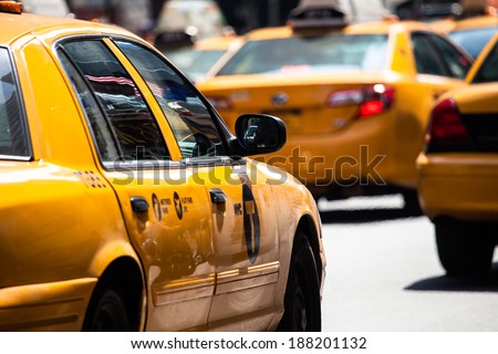 Yellow cab speeds through Times Square in New York, NY, USA.  Royalty-Free Stock Photo #188201132