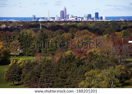 Cleveland - distant skyline view with colorful trees in the foreground.