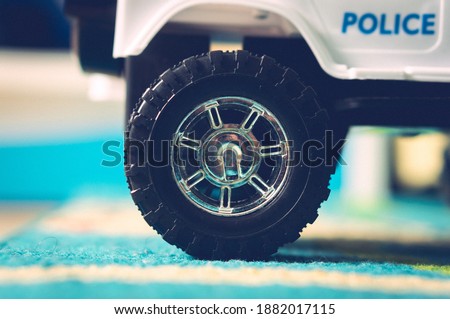 A closeup shot of a kid's toy car wheel on a carpet
