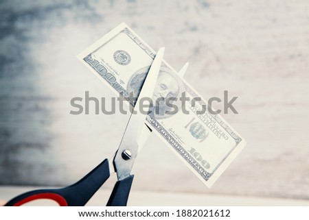Scissors cut a dollar bill in half