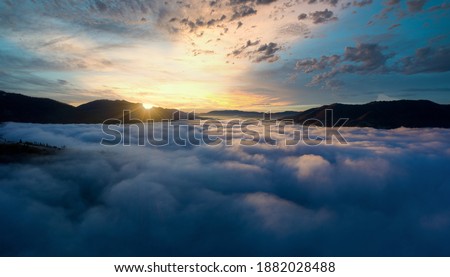 Sunrise over mountain hils covered with gray mist. Aerial panoramic drone shot Royalty-Free Stock Photo #1882028488