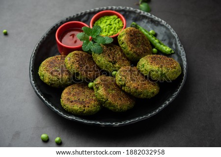 Hara bhara Kabab or Kebab is Indian vegetarian snack recipe served with green mint chutney over moody background. selective focus Royalty-Free Stock Photo #1882032958