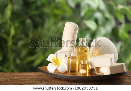 Beautiful spa composition with aroma oil and soap bars on wooden table. Space for text