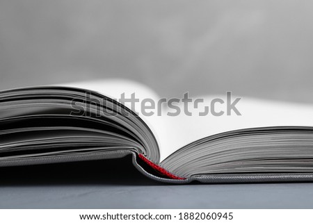 Open book with hard cover on grey table, closeup