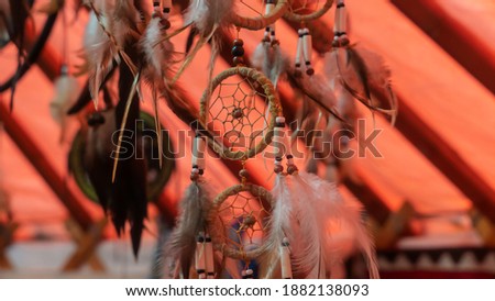 Close-up view of handmade dream catcher with feathers threads and beads rope hanging.
