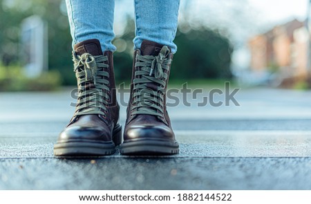 woman with brown boots standing on the crosswalk