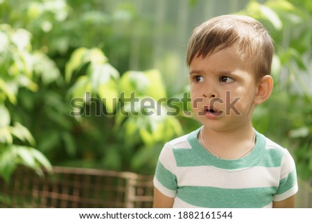 Summer, vacation, childhood, communication concepts. happy little surprised boy Persian appearance of eastern nationality is outside. Bright look of cute little boy aged 2 years. Close-up view of