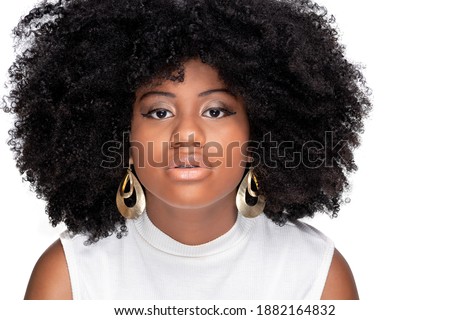 YOUNG BLACK GIRL WITH A LARGE AFRO STYLE HAIR AND LARGE GOLDEN EARRINGS
PHOTOGRAPHED IN CLOSE OLANDO FOR CAMERA, ISOLATED ON WHITE BACKGROUND