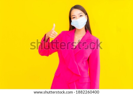 Portrait beautiful young asian woman wear mask for protect coronavirus or covid19 on yellow color background