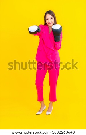 Portrait beautiful young asian woman with boxing on yellow isolated background