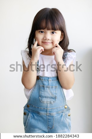 Portrait of three years cute little fair black hair Asian girl kid wearing casual cloth smiling and looking to camera with a lovely pose. Idea for a good healthy and happy adorable kid
