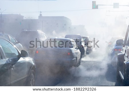 pollution from the exhaust of cars in the city in the winter. Smoke from cars on a cold winter day Royalty-Free Stock Photo #1882292326