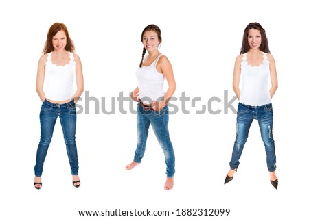 Full length portraits of three gorgeous young women wearing blue jeans and white tops, isolated on white studio background