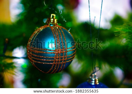 Beautiful multi-colored Christmas toys on the holiday tree with reflections of light