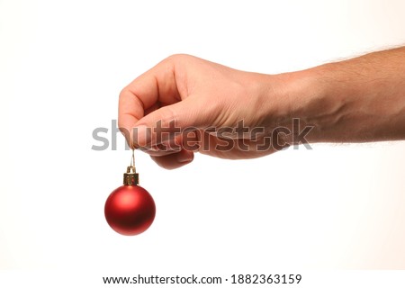 Red ball Christmas tree decoration in hand