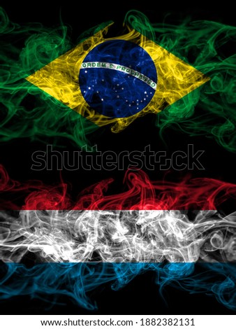Brazil, Brazilian vs Luxembourg smoky mystic flags placed side by side. Thick colored silky abstract smoke flags.