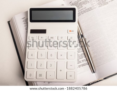 Calculator on open book or tax financial code with articles.